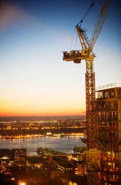 Fototapeta A crane on a high-rise building under construction.