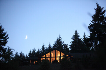 The quarter moon and a house in Oregon at dusk.