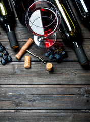 Wine background. Red wine with grapes and corkscrew.