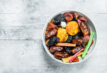 Assortment of different dried fruits in bowl.