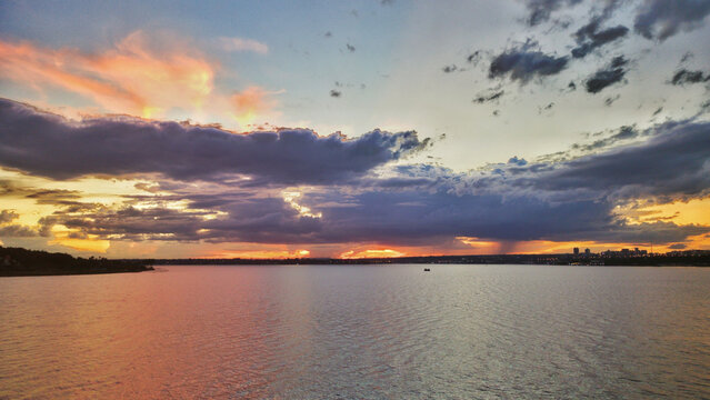 night photo of the Paranoa lake in Brasilia with the horizon in the background showing the sky with blue and orange clouds at dusk
