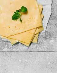 Thin slices of cheese with a branch of mint.
