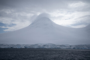 snowy mountain in antarctica with a cloud hat