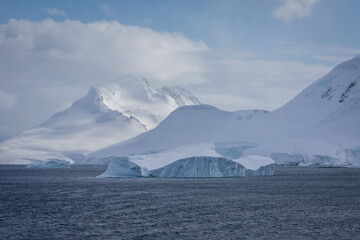 drift ice in antarctica with mountains behind