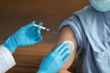 Unrecognizable Nurse Holding Syringe, Making Vaccine Shot To Male Patient