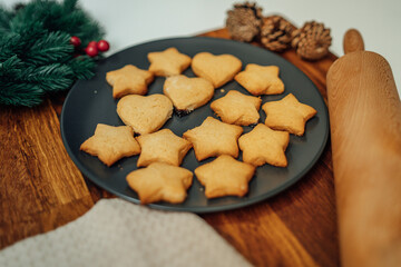 Top and side view of mother and daughter preparing gingerbread cookies with rolling pin in their kitchen in different shapes heart and stars 