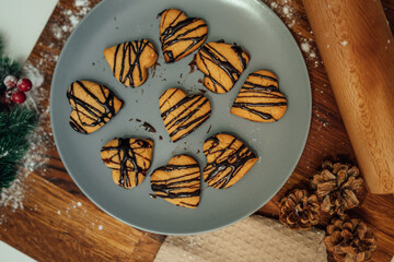 Top and side view of mother and daughter preparing gingerbread cookies with rolling pin in their kitchen in different shapes heart and stars 