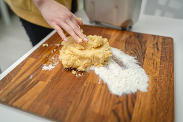 Top and side view of mother and daughter preparing gingerbread cookies with rolling pin in their kitchen in different shapes heart and stars 
