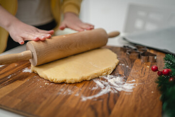 Top and side view of mother and daughter preparing gingerbread cookies with rolling pin in their kitchen in different shapes heart and stars 