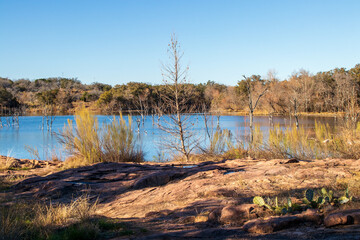 Texas hiking trails at Inks Lake State Park.  The ghost trees reflect in the pond.  Texas State Parks celebrates 100 years.