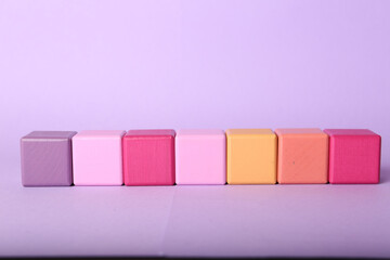 Empty colorful cubes on lilac background, space for design