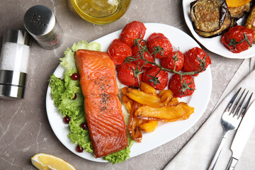 Tasty cooked salmon and vegetables served on grey table, flat lay. Healthy meals from air fryer
