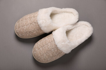 Pair of beautiful soft slippers on grey background, top view