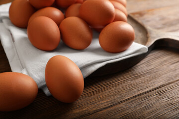 Raw brown chicken eggs on wooden table, closeup