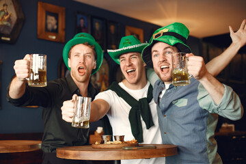 Men celebrate St. Patrick's Day at bar with a mug of beer