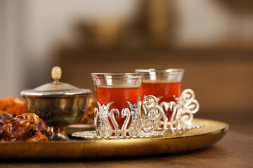 Glasses with tasty Turkish tea and oriental sweets on wooden table indoors, space for text