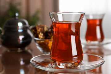 Glass with tasty Turkish tea on brown table indoors, closeup