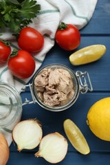 Flat lay composition with tasty cod liver and different products on blue wooden table