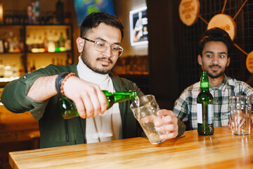 Indian friends celebrating in a pub with beer