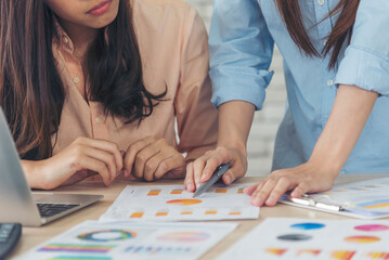 Fototapeta premium Happy success business woman partner working together in company office corporate executive teamwork. Meeting Executive Asian business woman using laptop office desk with fist arm raised win happiness