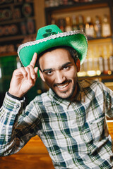 Indian guy in a green hat in a pub
