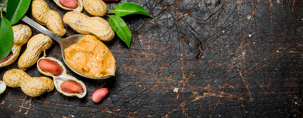 Peanut butter in a spoon with leaves .