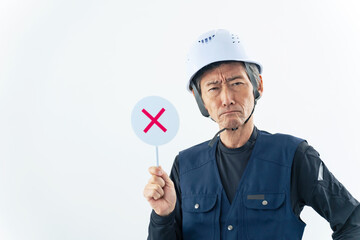 ばつ印を見せる職人