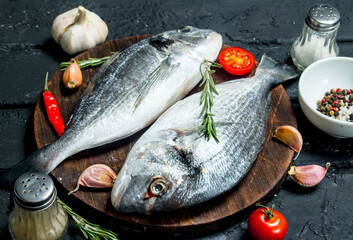 Raw sea fish dorado with spices and vegetables.
