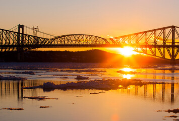 Fototapeta na wymiar Sun setting behind Quebec City's Old Bridge.