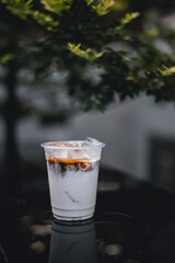 ice latte coffee in plastic glass on black table at cafe​