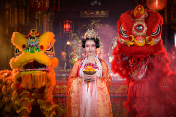 Fototapeta premium Chinese woman with yellow and red lions It is considered to enhance the prosperity for oneself on the occasion of the Chinese New Year festival every year