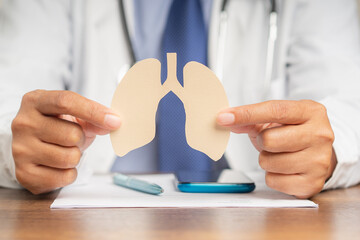 Doctor holding a lung shape symbol while sitting in the hospital