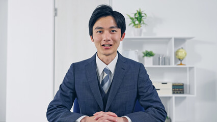 カメラ目線で話すビジネスマン　ビデオ通話　インタビュー