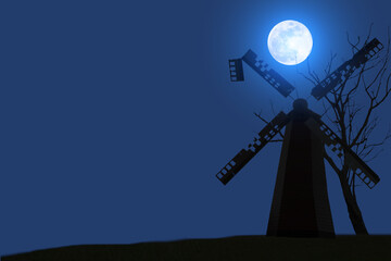 Fototapeta na wymiar Silhouette of a decaying windmill with dry trees on a full moon night.
