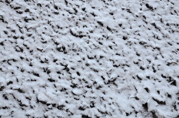 Texture of anthracite coal under a thin layer of snow as a graphic resource.