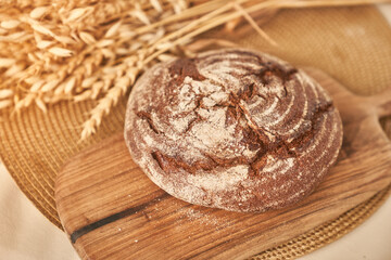 Whole grain bread on a wooden kitchen plate. Fresh bread on the table close-up. Fresh bread on the kitchen table. The concept of healthy eating and traditional bakery. High quality photo