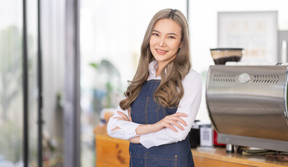 Fototapeta na wymiar Opening a small business, A Happy Asian woman in an apron standing near a bar counter coffee shop, Small business owner, restaurant, barista, cafe, Online, SME, entrepreneur, and seller concept