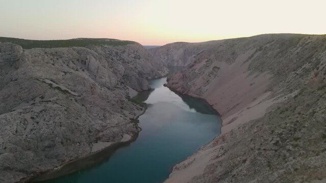 drone flying over man sitting on cliff in autumn season at huge sunset. The river zrmanja canyon.