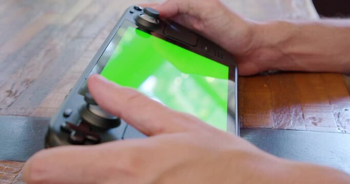A Steam Deck handheld video game system with a green screen display, perfect for inserting custom footage. Ideal for showcasing gaming or technology.