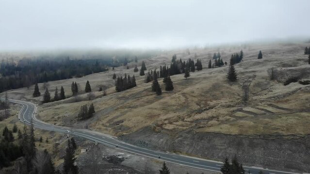 Highway By The Sloping Mountains On A Misty Morning. Aerial Shot