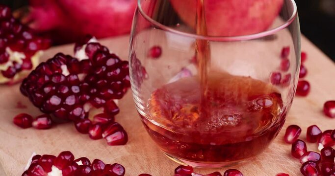 Red freshly squeezed pomegranate juice in a transparent glass, poured into a glass glass sweet and sour pomegranate juice