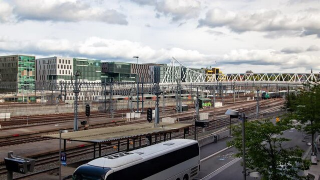 Wide railway with trains in the center of Oslo under modern buildings