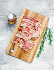 Raw bacon with rosemary and olive oil.