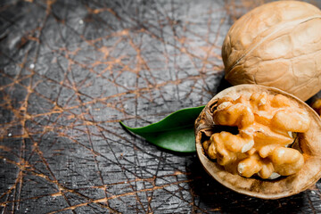 Shelled walnut with green leaves.