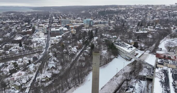 Winter aerial drone video of an abandoned industrial concrete smoke stack.	