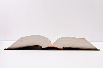 Open book and school supplies with a path on a white background.