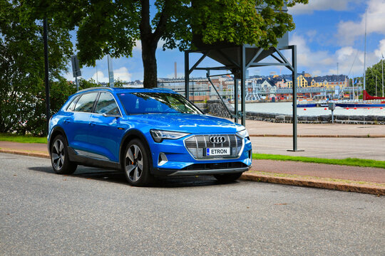 Blue Audi E-tron 55 quattro electric SUV Parked by Street with Seaside View. Copy Space for Text. 