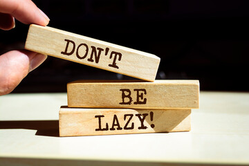 Wooden blocks with words 'Don't Be Lazy'.