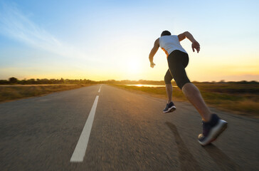 Action motion blur of a man running on country road with sunrise background... © Paitoon
