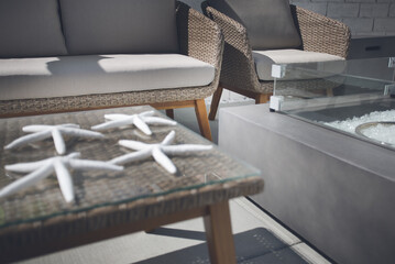 A view of stylish wicker patio furniture in a backyard lounge setting.